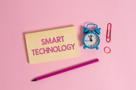 Word writing text Smart Technology. Business photo showcasing gadgets or device that has a built in computer or chip Colorful blank notepad marker retro alarm clock clip colored backgroundの写真素材