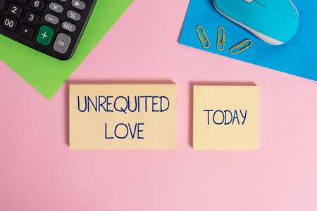 Writing note showing Unrequited Love. Business concept for not openly reciprocated or understood as such by beloved Wire mouse portable calculator notepads paper sheets color backgroundの写真素材