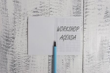 Conceptual hand writing showing Workshop Agenda. Concept meaning helps you to ensure that your place stays on schedule Square notebook fine highlighter lying on wooden backgroundの写真素材