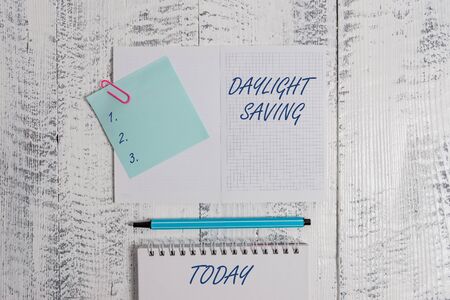 Word writing text Daylight Saving. Business photo showcasing Storage technologies that can be used to protect data Open squared spiral notepad clip note highlighter lying old wooden backgroundの写真素材