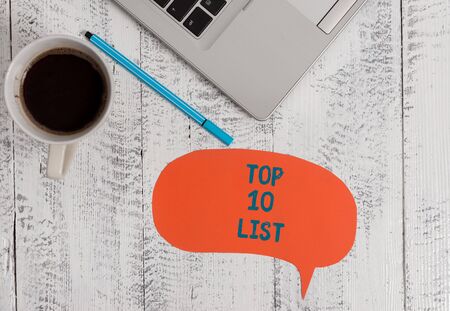Text sign showing Top 10 List. Business photo showcasing the ten most important or successful items in a particular list Metallic open laptop speech bubble coffee cup ballpoint pen vintage tableの写真素材