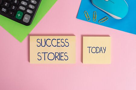 Writing note showing Success Stories. Business concept for life of rule models from how he started to his death Wire mouse portable calculator notepads paper sheets color backgroundの写真素材