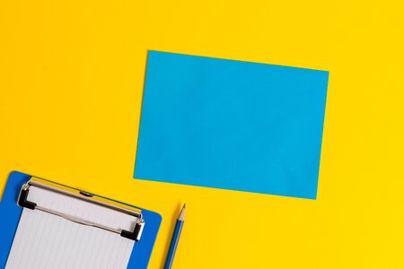 Clipboard holding blank paper sheet square page pencil colored backgroundの写真素材