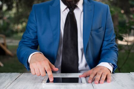 Businessman in blue suite with a tie holds lap top in hands.の写真素材
