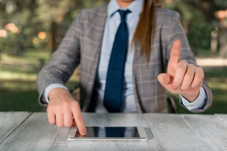 Business concept with female business person sitting by the table and holding mobile phone.の写真素材