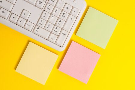 Colored empty papers with copy space on the yellow background table with pc keyboard.の写真素材