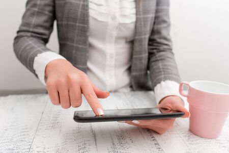 Business concept with mobile phone in the hand. Pointing with finger on the touch screenの写真素材