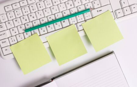 Three empty green square papers by the pc keyboard with copy space.の写真素材