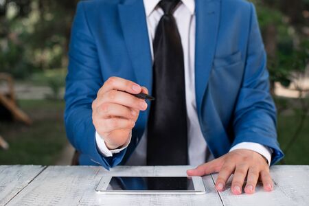 Businessman holds pen and points into copy space.の写真素材