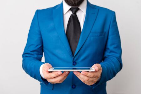 Businessman in blue suite with a tie holds lap top in hands.の写真素材