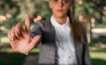 Business woman in the nature pointing with the finger into empty space.