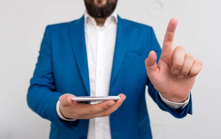 Businessman in the blue suite with lap top pointing with finger.の写真素材