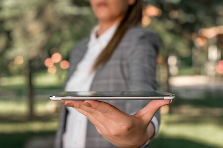 Outdoor scene with business woman holds lap top with touch screen.の写真素材