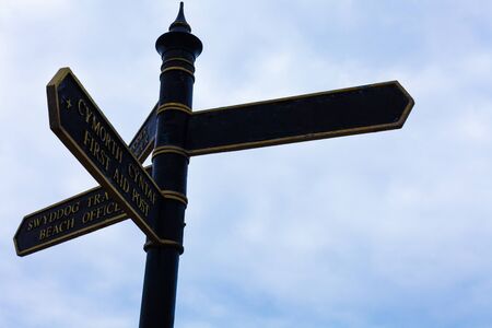 Road sign on the crossroads with blue cloudy sky in the background.の写真素材