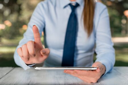 Business concept with female business person sitting by the table and holding mobile phone.の写真素材