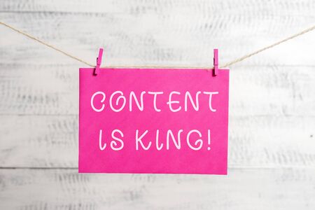 Word writing text Content Is King. Business photo showcasing marketing focused growing visibility non paid search results Clothesline clothespin rectangle shaped paper reminder white wood deskの写真素材