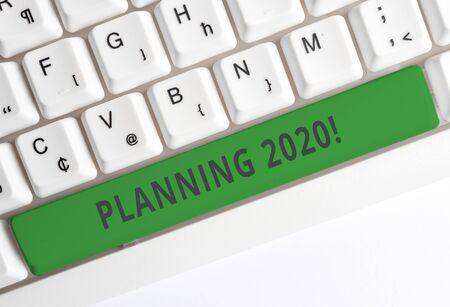 Text sign showing Planning 2020. Business photo showcasing process of making plans for something next year White pc keyboard with empty note paper above white background key copy spaceの写真素材