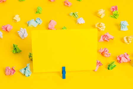Colored crumpled papers empty reminder white floor background clothespin