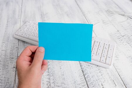 man holding colorful reminder square shaped paper white keyboard wood floorの写真素材