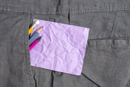 Writing equipment and purple note paper inside pocket of man work trousersの写真素材