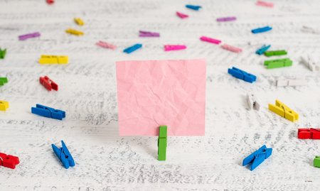 Green clothespin white wood background colored paper reminder office supply