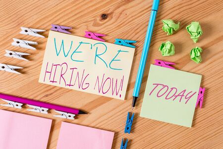 Handwriting text writing We Re Hiring Now. Conceptual photo recently employ someone or pay someone to do particular job Colored clothespin papers empty reminder wooden floor background officeの写真素材