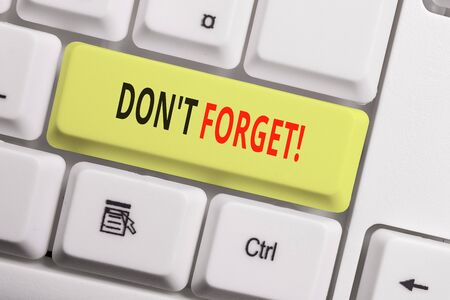 Text sign showing Don T Forget. Business photo showcasing used to remind someone about an important fact or detail White pc keyboard with empty note paper above white background key copy spaceの写真素材