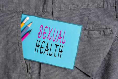 Conceptual hand writing showing Sexual Health. Concept meaning positive and respectful approach to sexual relationships Writing equipment and blue note paper in pocket of trousersの写真素材