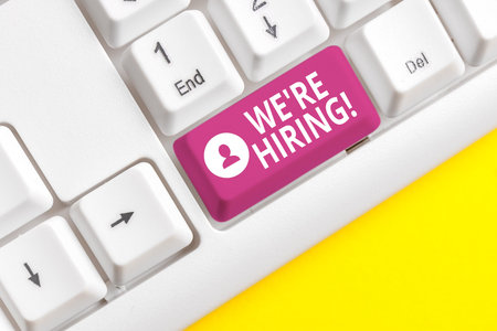 Writing note showing We Re Hiring. Business concept for recently employ someone or pay someone to do particular job White pc keyboard with note paper above the white backgroundの写真素材