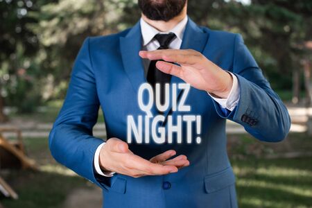 Handwriting text Quiz Night. Conceptual photo evening test knowledge competition between individuals Man with opened hands stands in suite.の写真素材