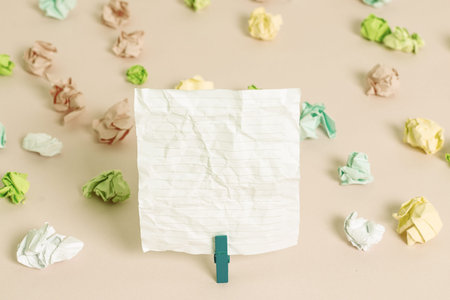 Colored crumpled papers empty reminder pink floor background clothespin