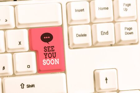 Text sign showing See You Soon. Business photo showcasing used for saying goodbye to someone and going to meet again soon White pc keyboard with empty note paper above white background key copy spaceの写真素材