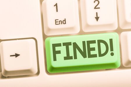 Text sign showing Fined. Business photo showcasing clarify beer by causing precipitation of sediment during production White pc keyboard with empty note paper above white background key copy spaceの写真素材