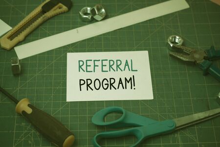 Handwriting text Referral Program. Conceptual photo internal recruitment method employed by organizations Carpentry equipments and plain paper scattered everywhere on measuring matの写真素材