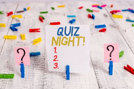 Text sign showing Quiz Night. Business photo showcasing evening test knowledge competition between individuals Scribbled and crumbling sheet with paper clips placed on the wooden tableの写真素材