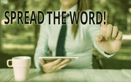 Conceptual hand writing showing Spread The Word. Concept meaning share the information or news using social media Female business person sitting by table and holding mobile phoneの写真素材