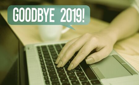 Word writing text Goodbye 2019. Business photo showcasing express good wishes when parting or at the end of last year woman laptop computer smartphone mug office supplies technological devicesの写真素材