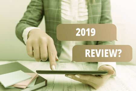 Writing note showing 2019 Review Question. Business concept for remembering past year events main actions or good shows Business concept with mobile phone in the handの写真素材