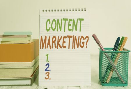 Text sign showing Content Marketing Question. Business photo text involves creation and sharing of online material Pens metal holder stacked note pads books square box spiral wooden tableの写真素材