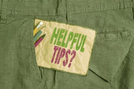Handwriting text writing Helpful Tips Question. Conceptual photo secret information or advice given to be helpful knowledge Writing equipment and brown note paper inside pocket of man work trousersの写真素材