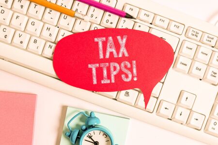 Handwriting text Tax Tips. Conceptual photo compulsory contribution to state revenue levied by government Empty copy space red note paper bubble above pc keyboard for text messageの写真素材