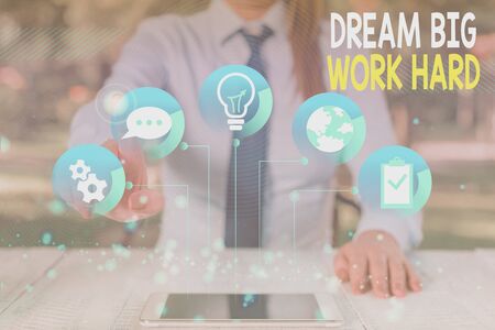 Conceptual hand writing showing Dream Big Work Hard. Concept meaning Believe in yourself and follow the dreams and goals Female human wear formal work suit presenting smart deviceの写真素材