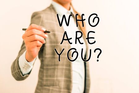 Writing note showing Who Are Youquestion. Business concept for someone asking your demonstratingal background or history Business woman pointing in empty space with penの写真素材