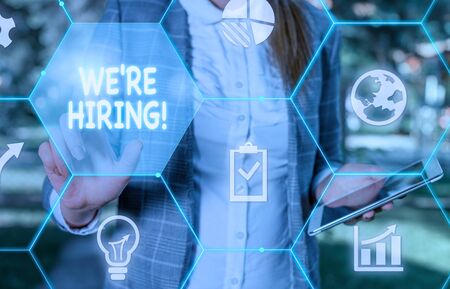 Handwriting text writing We Re Hiring. Conceptual photo process of reviewing applications and finding candidates Female human wear formal work suit presenting presentation use smart deviceの写真素材