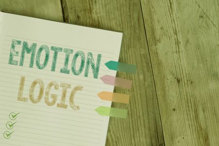 Handwriting text writing Emotion Logic. Conceptual photo Heart or Brain Soul or Intelligence Confusion Equal Balance Striped note book four colored arrow banners reminder wooden backgroundの写真素材
