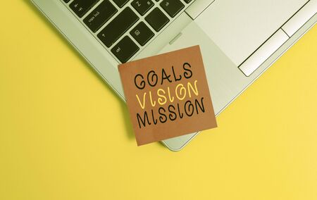 Writing note showing Goals Vision Mission. Business concept for practical planning process used to help community group Metallic trendy laptop blank sticky note empty text colored backgroundの写真素材