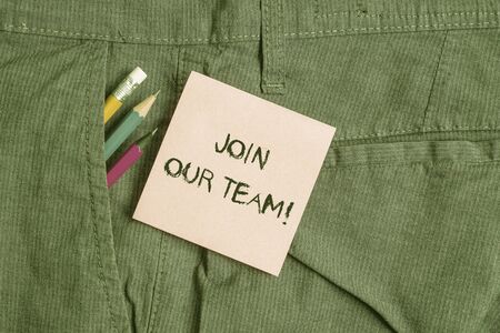 Conceptual hand writing showing Join Our Team. Concept meaning invite someone to work together for particular purpose target Writing equipment and pink note paper inside pocket of trousersの写真素材
