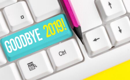 Handwriting text writing Goodbye 2019. Conceptual photo express good wishes when parting or at the end of last year White pc keyboard with empty note paper above white background key copy spaceの写真素材