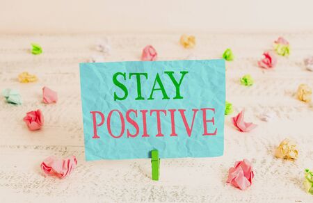 Word writing text Stay Positive. Business photo showcasing Engage in Uplifting Thoughts Be Optimistic and Real Green clothespin white wood background colored paper reminder office supplyの写真素材