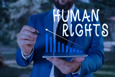Word writing text Huanalysis Rights. Business photo showcasing Moral Principles Standards Norms of a showing protected by Law Male human wear formal work suit presenting presentation using smart deviceの写真素材